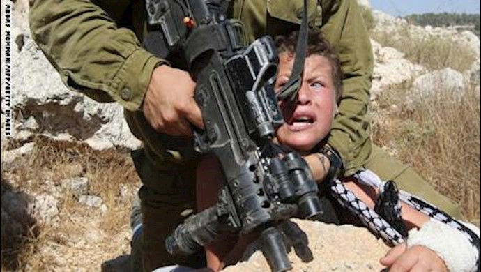 انتشار واسع لصورة جندي إسرائيلي يثبت رأس طفل فلسطيني.. ووالده لـCNN: کنت موجودا ويصعب علی أي اب رؤية حصول ذلک لابنه