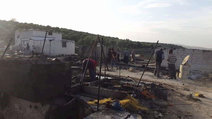 بالصور.. طائرة مسيرة تحرق مخيماً کاملاً في جسر الشغور+فيديو
